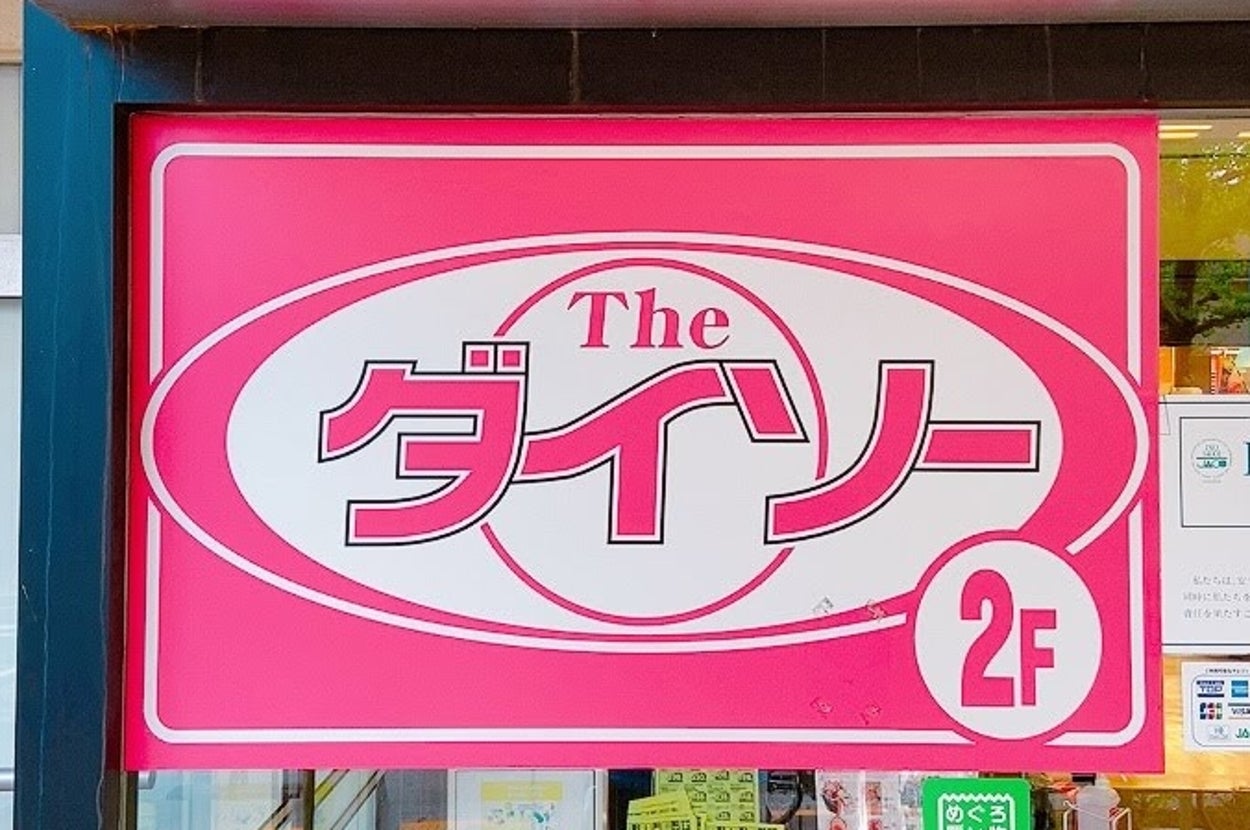 店舗の入口に「The ダイソー 2F」と書かれた看板が表示されています。