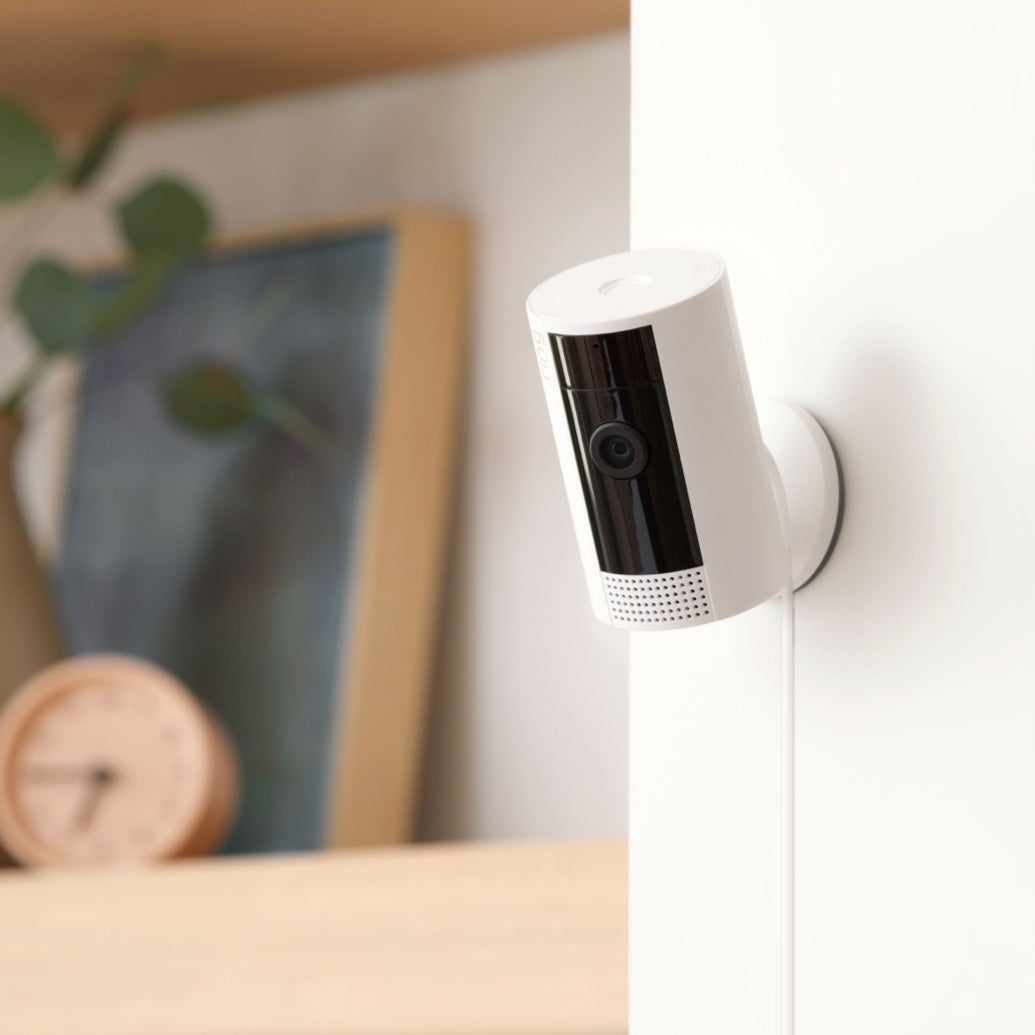 Smart location  information    camera mounted connected  a wall, with a timepiece  and framed photograph  blurred successful  the background
