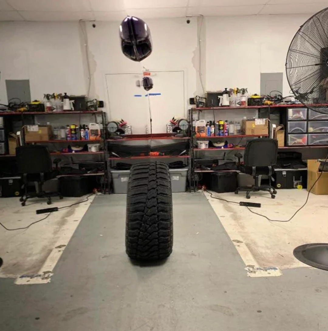 Tire hanging successful  a store  with workbenches and shelves filled with tools and supplies. Two bureau   chairs are disposable   nearby