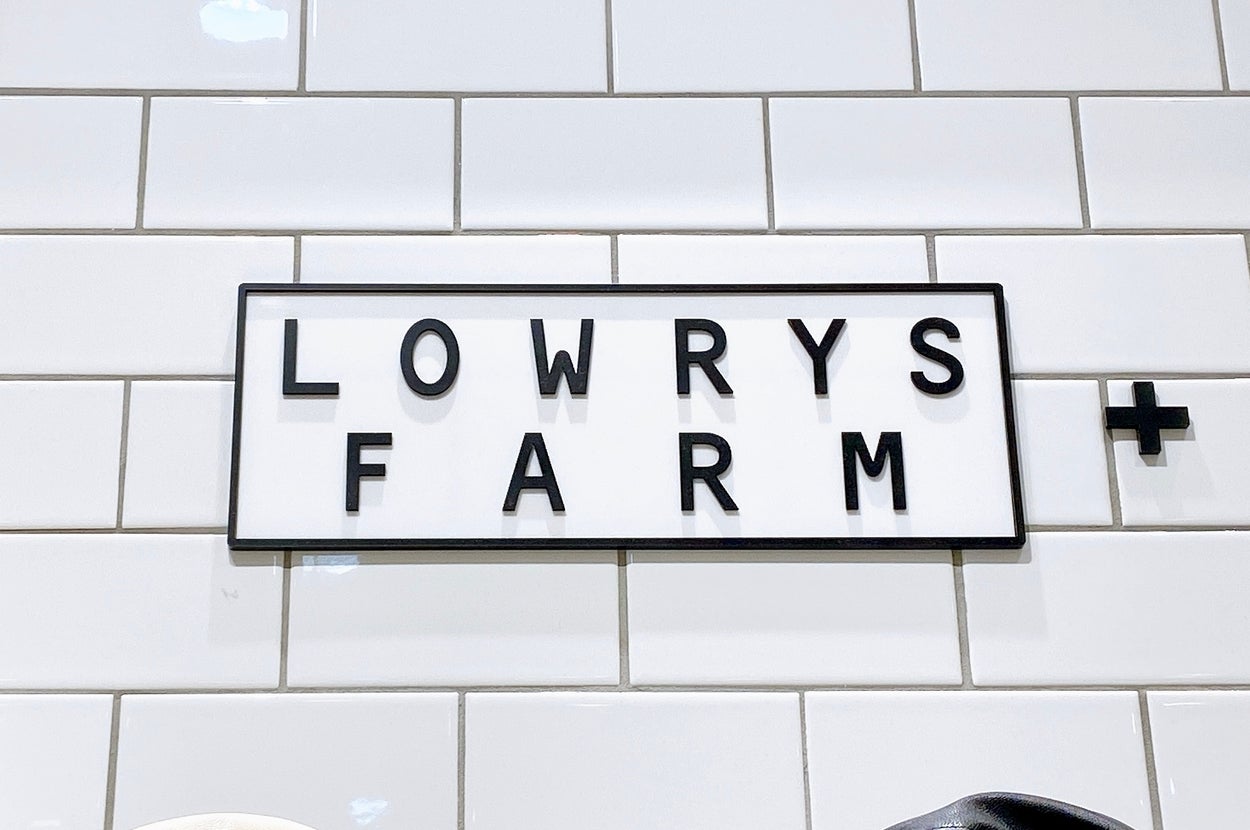 LOWRYS FARMのロゴがプラス記号と共にタイルの壁に掲示されています。
