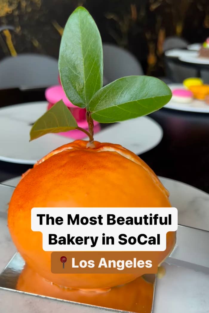 A dessert shaped like an orange with a leaf sits on a plate, labeled "The Most Beautiful Bakery in SoCal, Los Angeles."