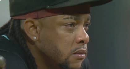 Athlete with earrings appears emotional on the field, looking intently across the scene