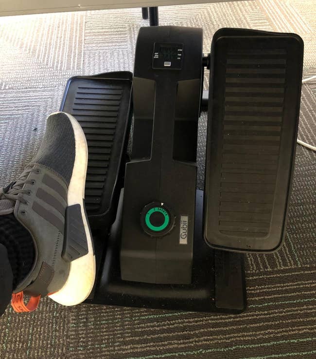 Under-desk elliptical with a reviewer's ft connected 1 pedal