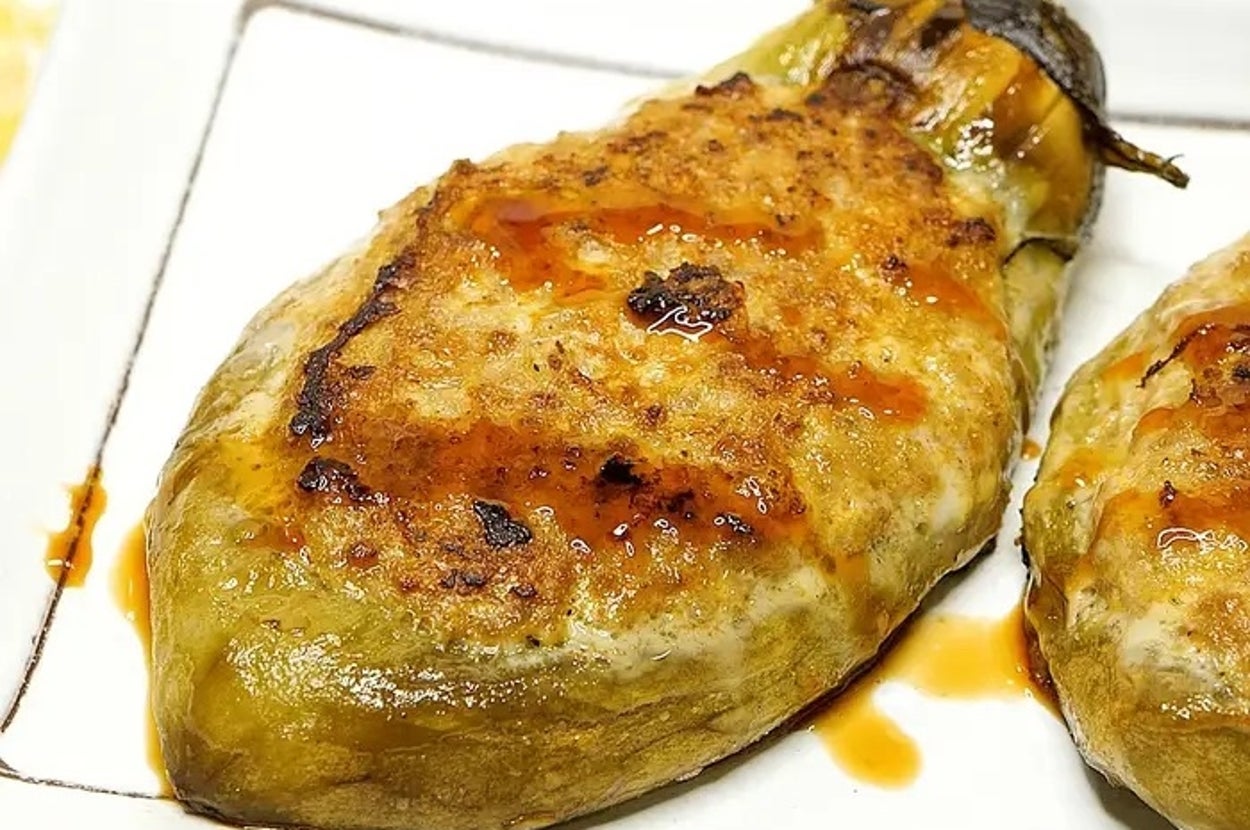 皿の上に焼かれたナスが盛られている。焼き目やソースのかかった美味しそうな料理。