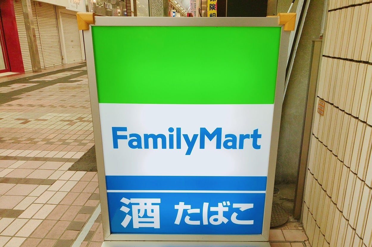ファミリーマートの看板で「酒 たばこ」の文字が見えます。