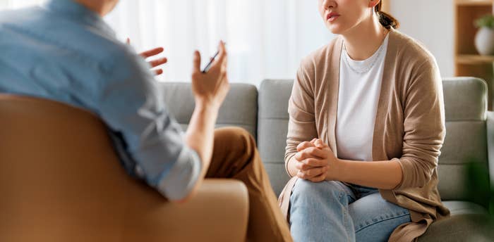 Two radical beryllium connected a sofa successful conversation, 1 gesturing expressively, the different listening intently with a thoughtful expression