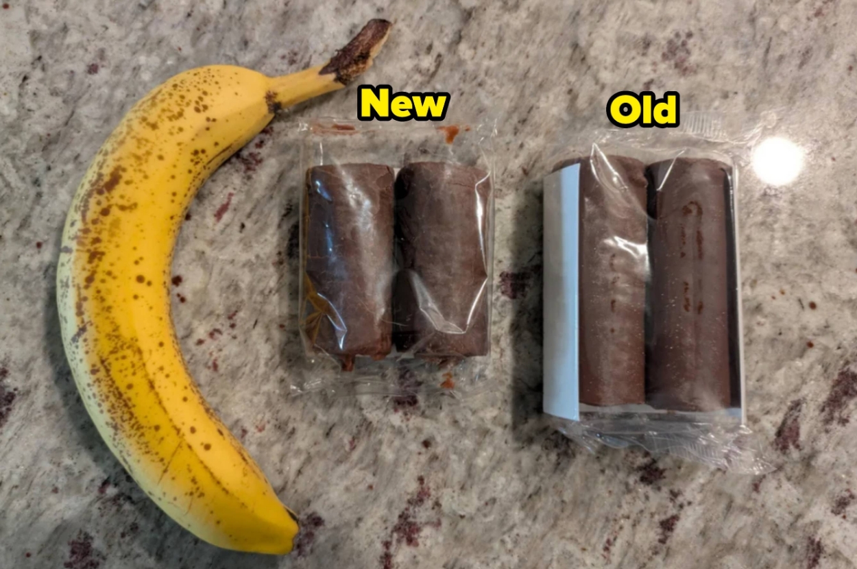 Banana next to two wrapped packages of swiss cake rolls labeled "New" and "Old," showing size comparison