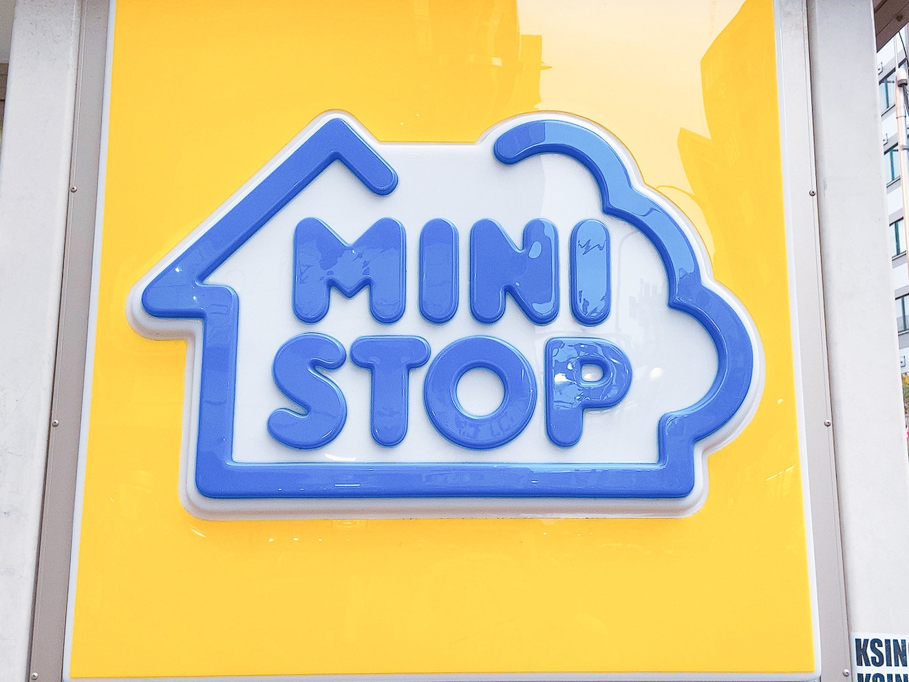 ミニストップの店舗看板。青い文字で「MINI STOP」と書かれた家の形をしたデザイン。