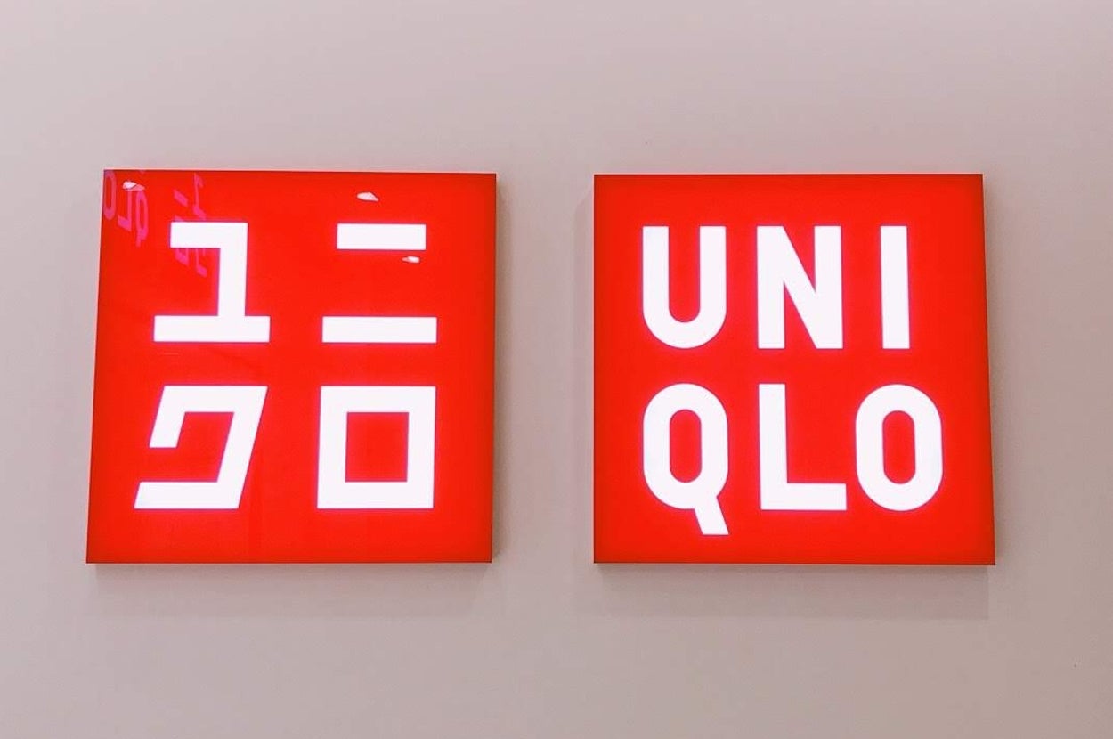 Two signs display "ユニクロ" in Japanese and "UNI QLO" in English, indicating the Uniqlo brand