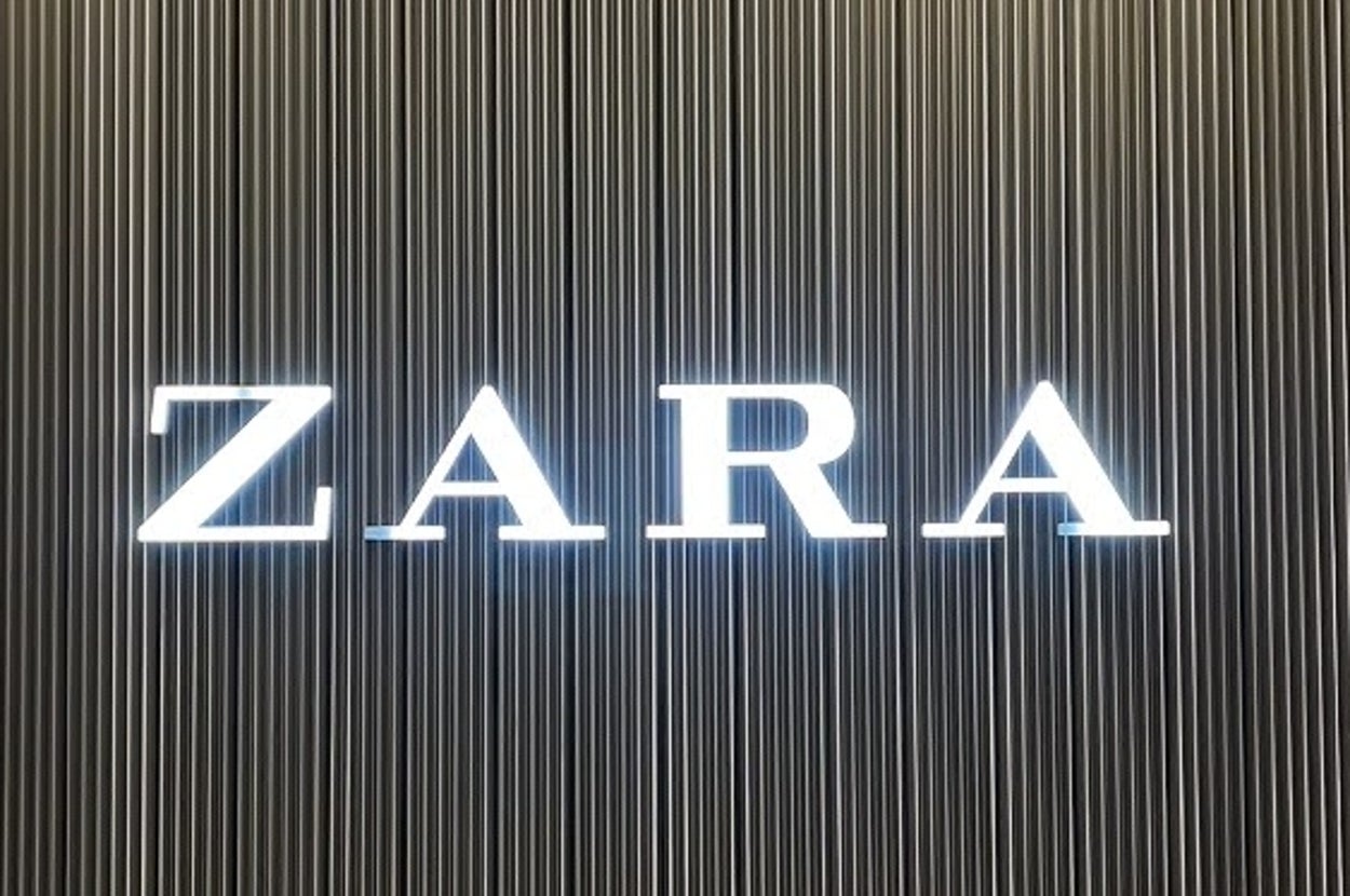 The image shows a ZARA logo on a wall with vertical lines