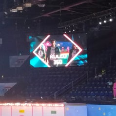 Large screen showing "Kuki 360" in an auditorium with people seated in the background