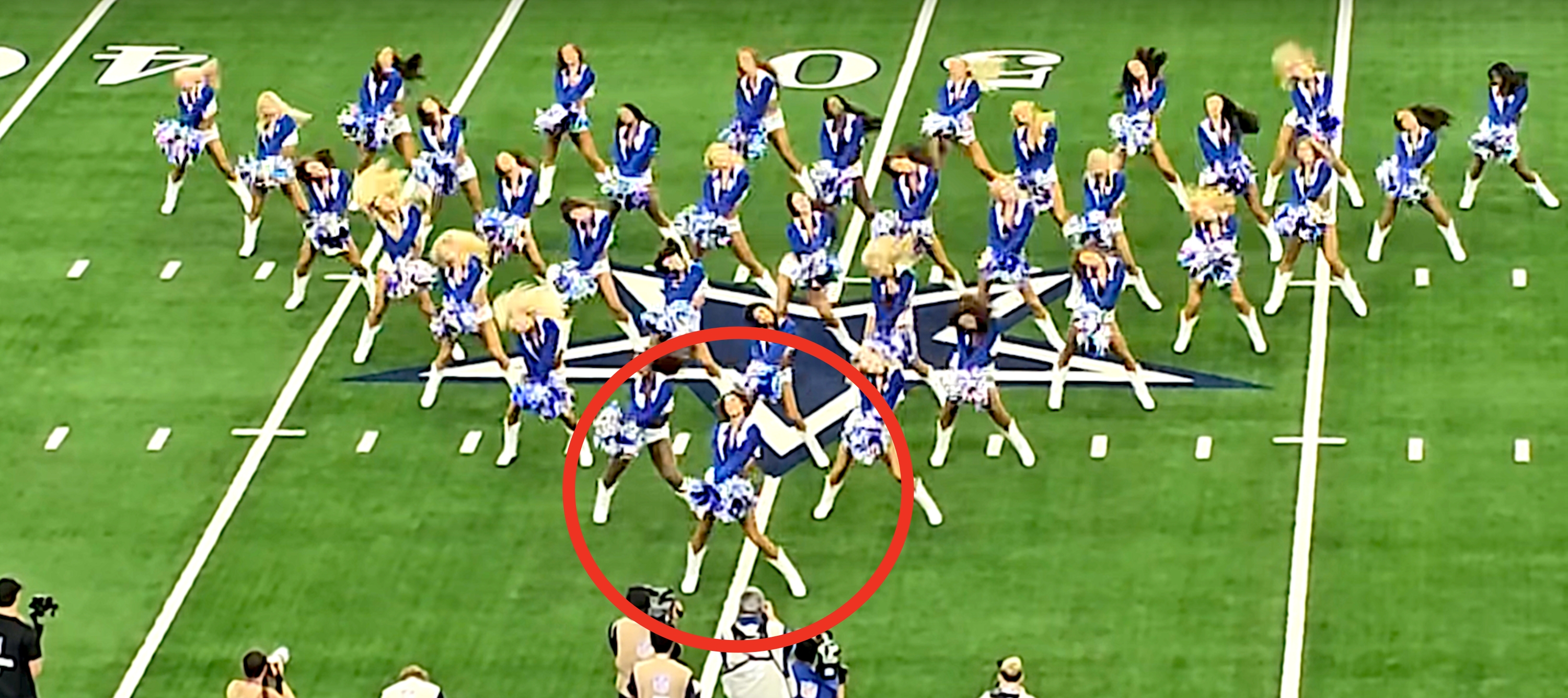 A group of cheerleaders performing a choreographed routine on a football field, each wearing matching uniforms with pompoms
