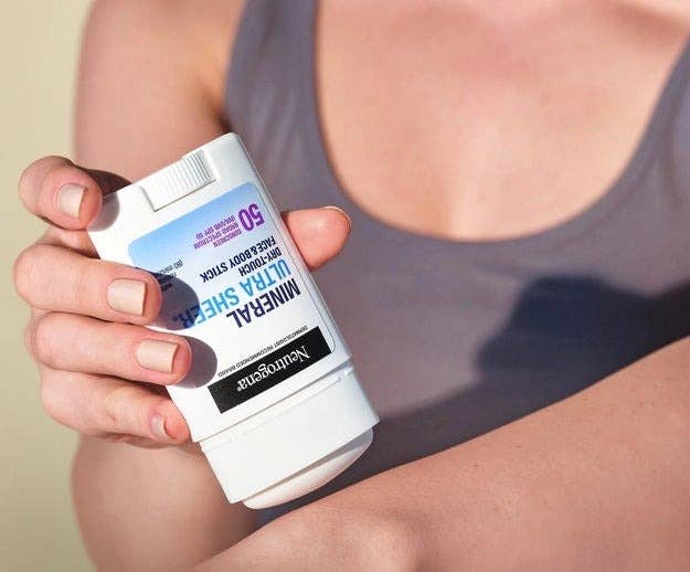 Person applies Neutrogena Mineral Ultra Sheer SPF 50 sunscreen connected their arm, showcasing skincare extortion product