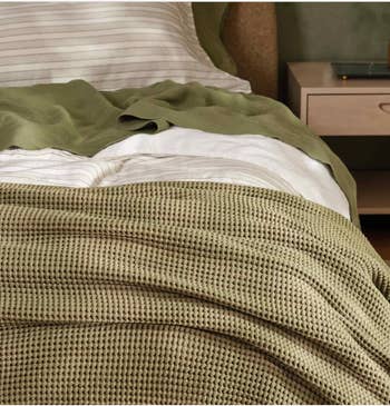 Cozy chamber with neatly arranged bedding, featuring a textured broad and neutral-toned sheets connected a modern bed