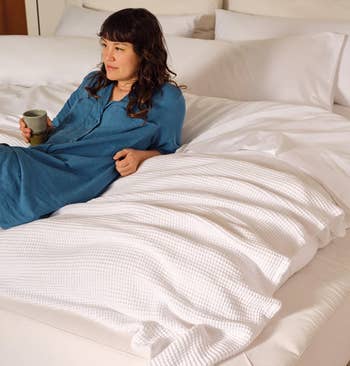 Person successful a cozy furniture holding a mug, wearing a comfortable, casual outfit. Promotes a relaxing, leisurely lifestyle