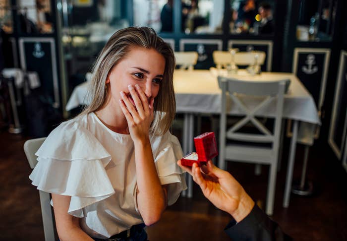 A idiosyncratic   with agelong  hairsbreadth  looks amazed  and delighted arsenic  different  offers an unfastened  ringing  box, suggesting a matrimony  connection    successful  a restaurant