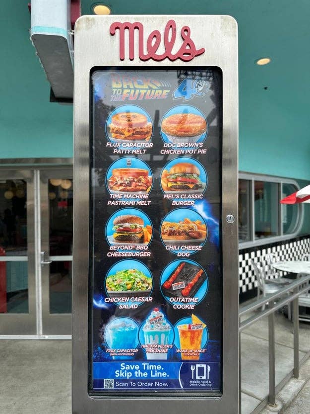 Diner menu board featuring themed items like “Flux Capacitor Patty Melt” and “Doc Brown’s Chicken Pot Pie.” Options include burgers, salads, and desserts