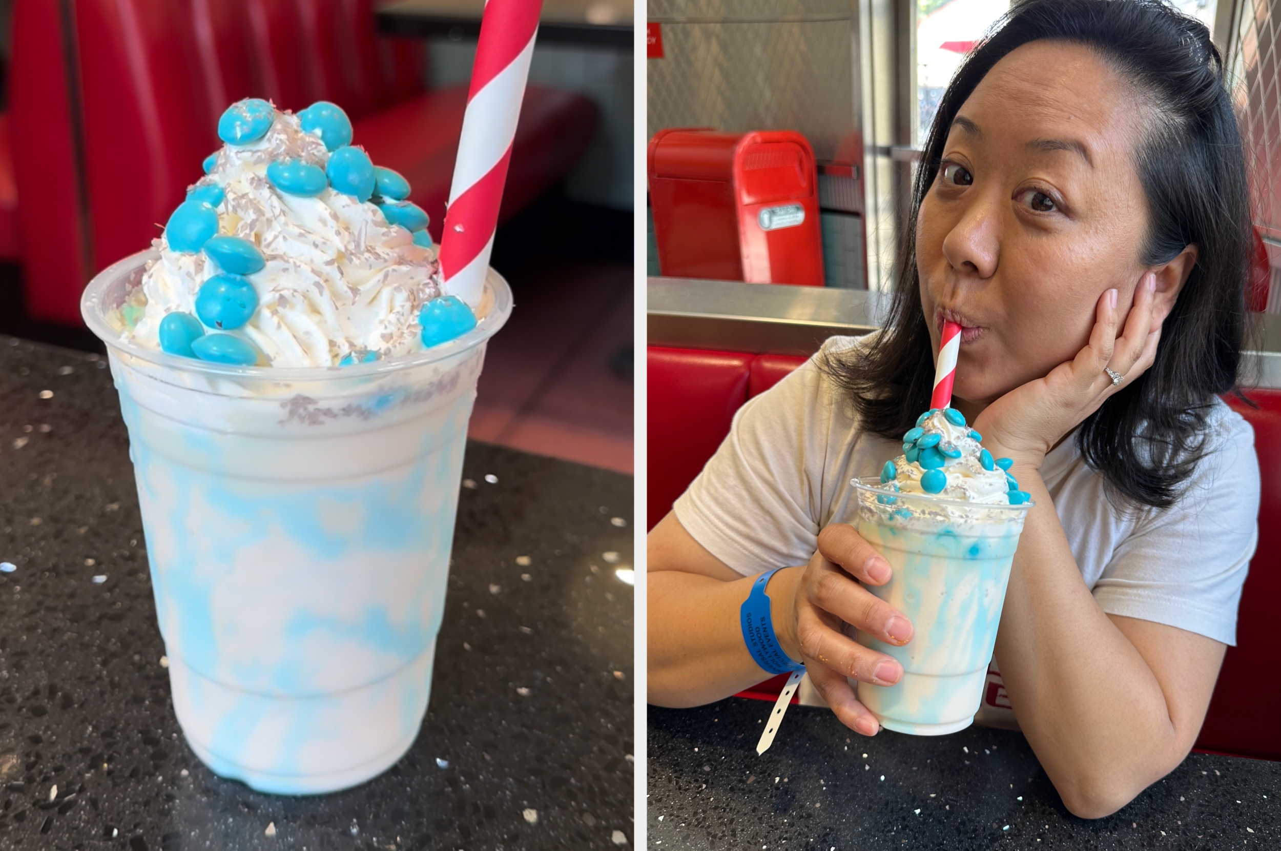 A woman enjoys a blue and white milkshake with whipped cream and blue candy in a diner setting