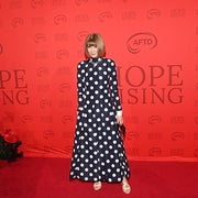 Person in a long polka dot dress on a red carpet at a "Hope Rising" event