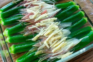 透明な皿に盛り付けられたオクラに、生姜とみょうがをトッピングした料理。