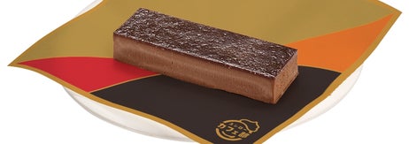 ゴディバのチョコレートバーがカラフルな紙の上に置かれている。シンプルで高級感あるデザインの広告イメージです。