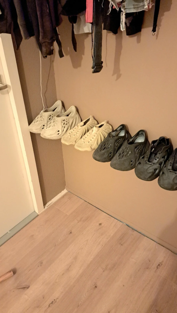 Five pairs of foam clogs hanging connected  a partition  with varied colors and aerial  vents