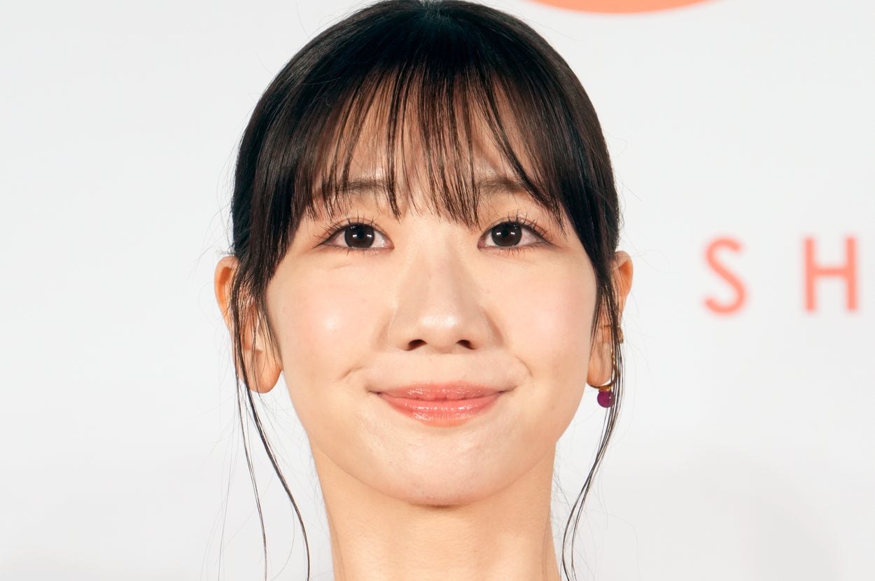 女性がフリルのドレスでイベントに参加し、カメラに向かって微笑んでいる。