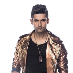 Person posing in a studded metallic jacket with a black shirt, hands in pockets