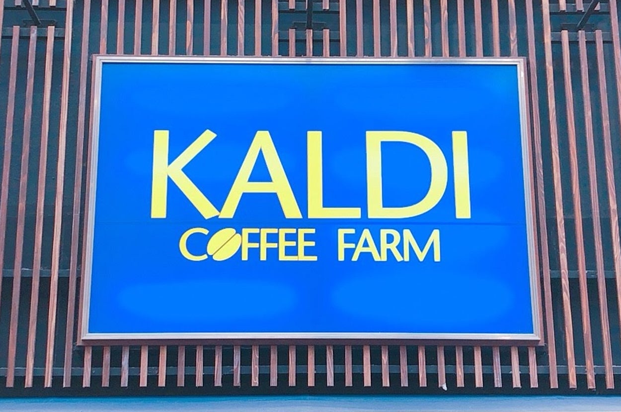 建物の外にある「KALDI COFFEE FARM」の青い看板。下には「SPRING MARKET」と書かれた装飾がある。
