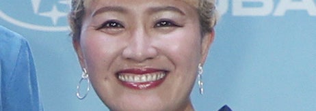 女性がレースのドレスを着て微笑んでいる。