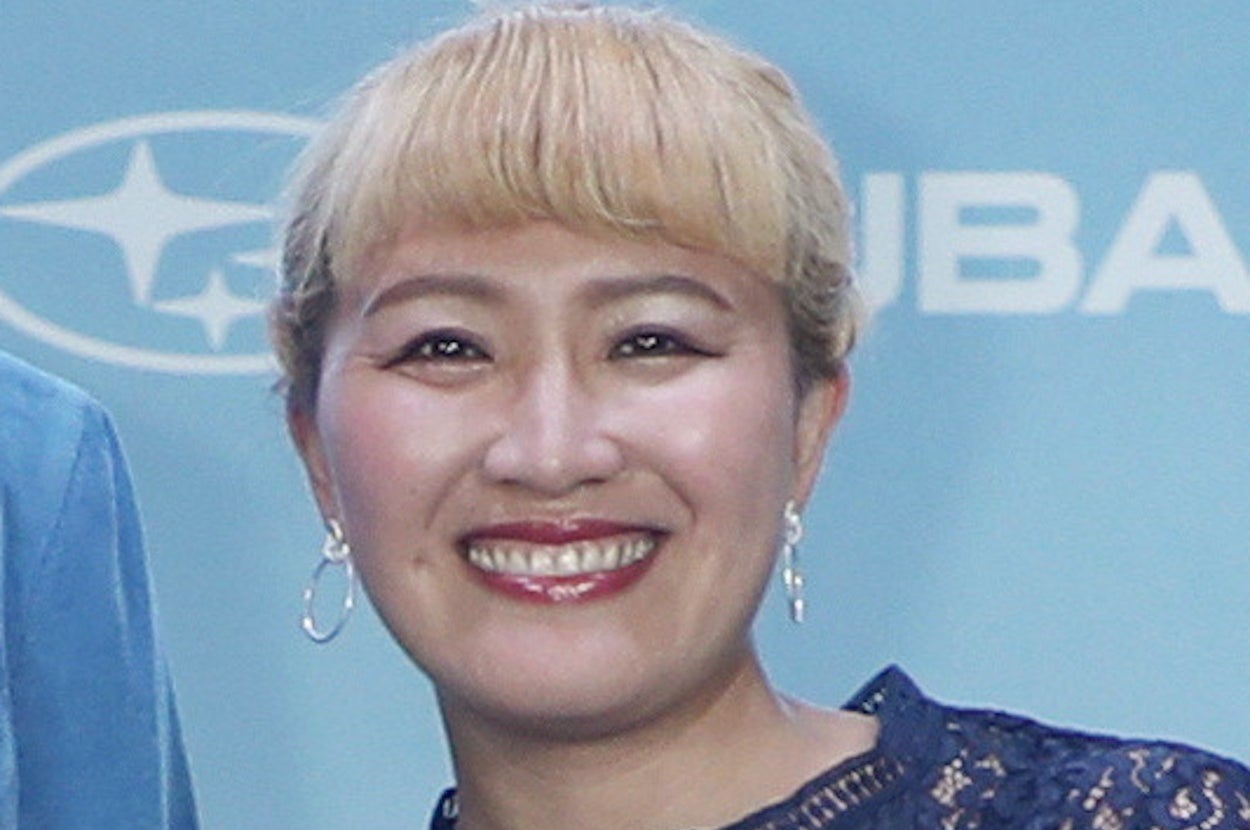 女性がレースのドレスを着て微笑んでいる。