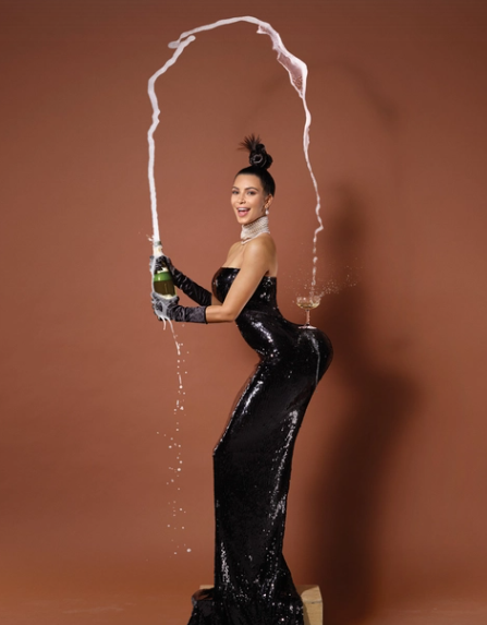 Person in a glamorous, form-fitting sequin gown creatively pouring a bottle of champagne with an exuberant splash