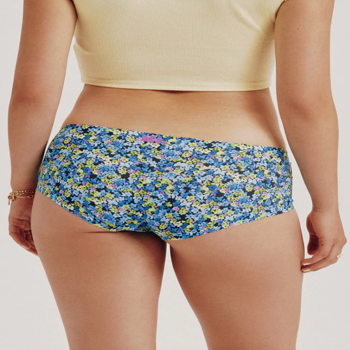 Person wearing floral-patterned underwear standing with back facing the camera