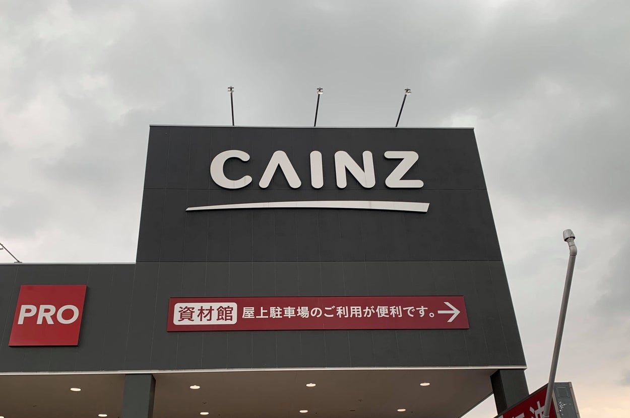 ホームセンター「CAINZ」の看板と店舗の外観。屋上駐車場の利用案内が掲示されている。