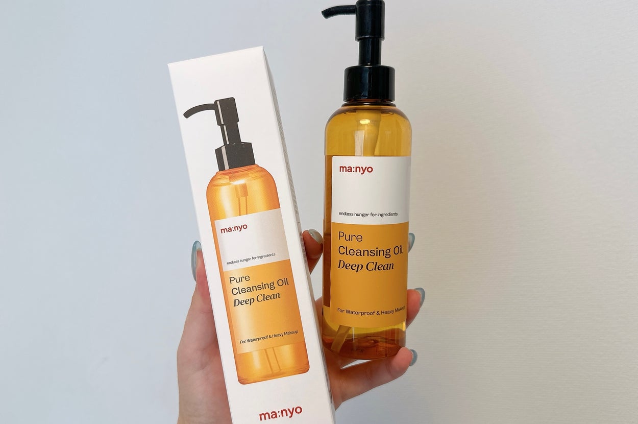 手に持たれたmanyoの「Pure Cleansing Oil Deep Clean」のボトルと箱。クレンジング商品。