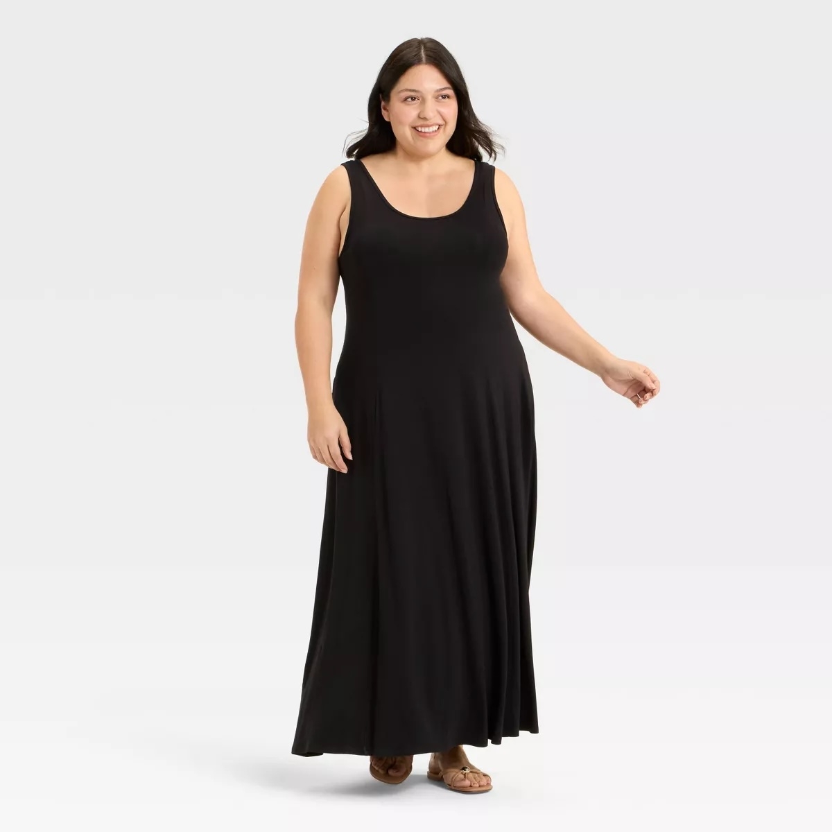 Smiling model in a sleeveless black maxi dress, standing and posing, perfect for stylish and comfortable shopping looks