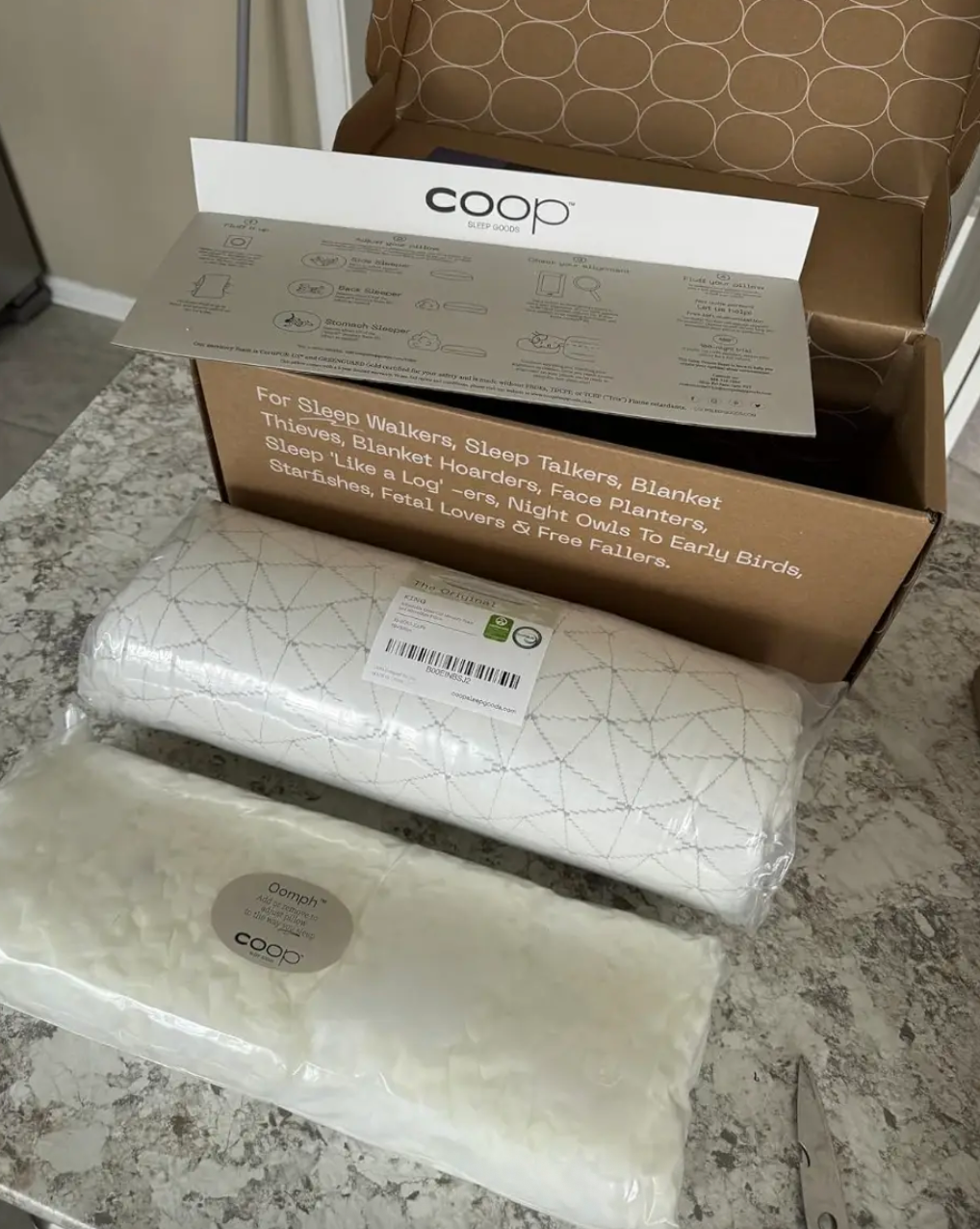 Box of Coop Home Goods pillows on a counter, featuring extras for sleep comfort
