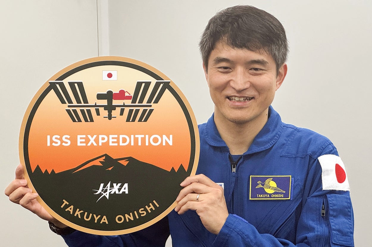 宇宙飛行士/ミッションマークを持つ大西卓哉さん(時事)