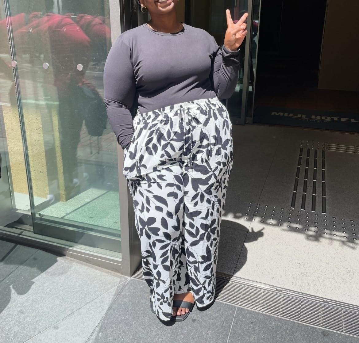 Person wearing a long-sleeve apical  and patterned wide-leg pants