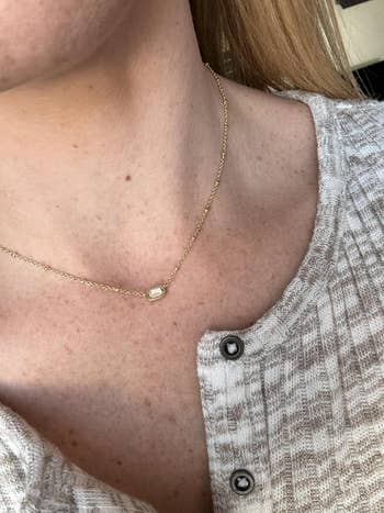 Close-up of a idiosyncratic wearing a bladed concatenation necklace with a tiny pendant