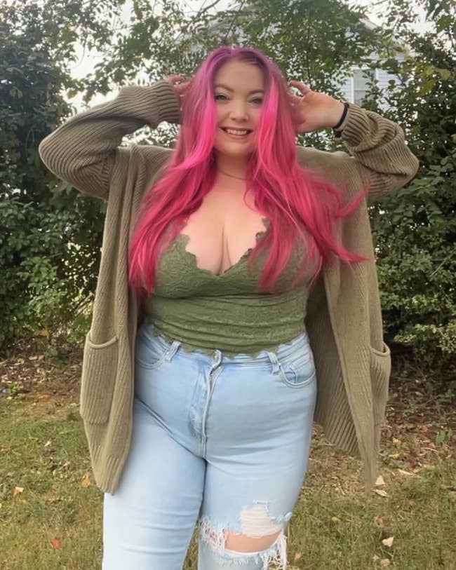 Person outdoors wearing a cardigan, lace top, and ripped jeans