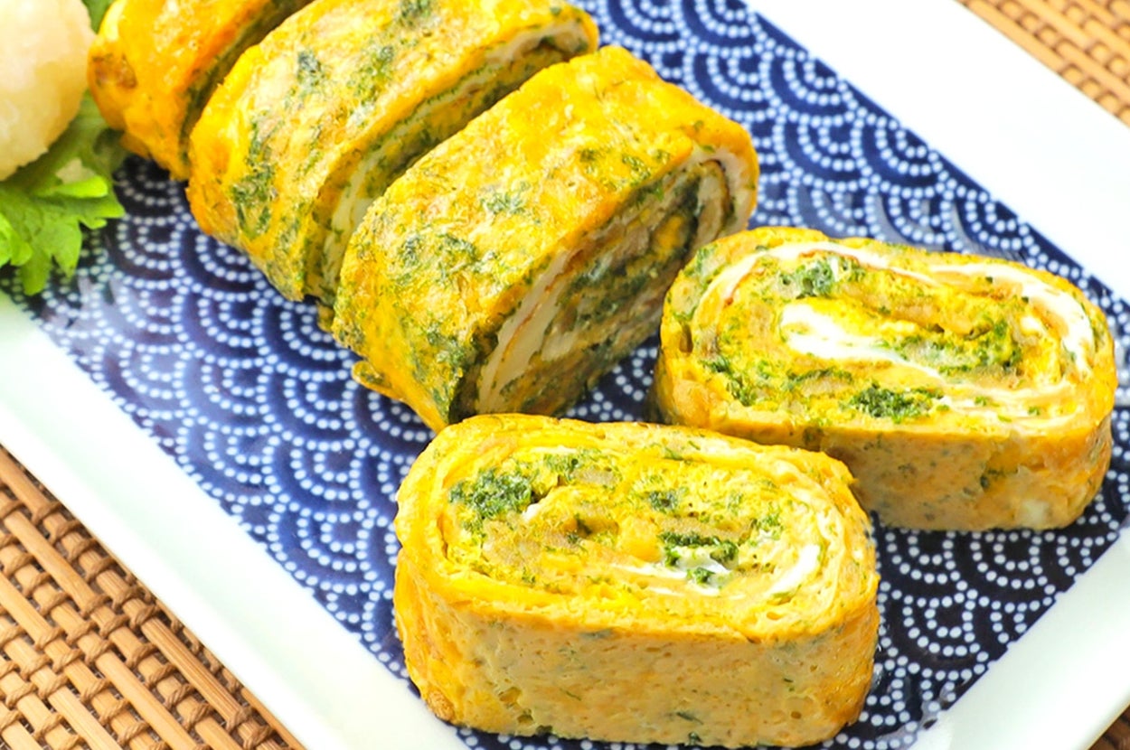 卵焼きが青海波模様の皿に盛られている。隣に大根おろしと三つ葉が添えられている。