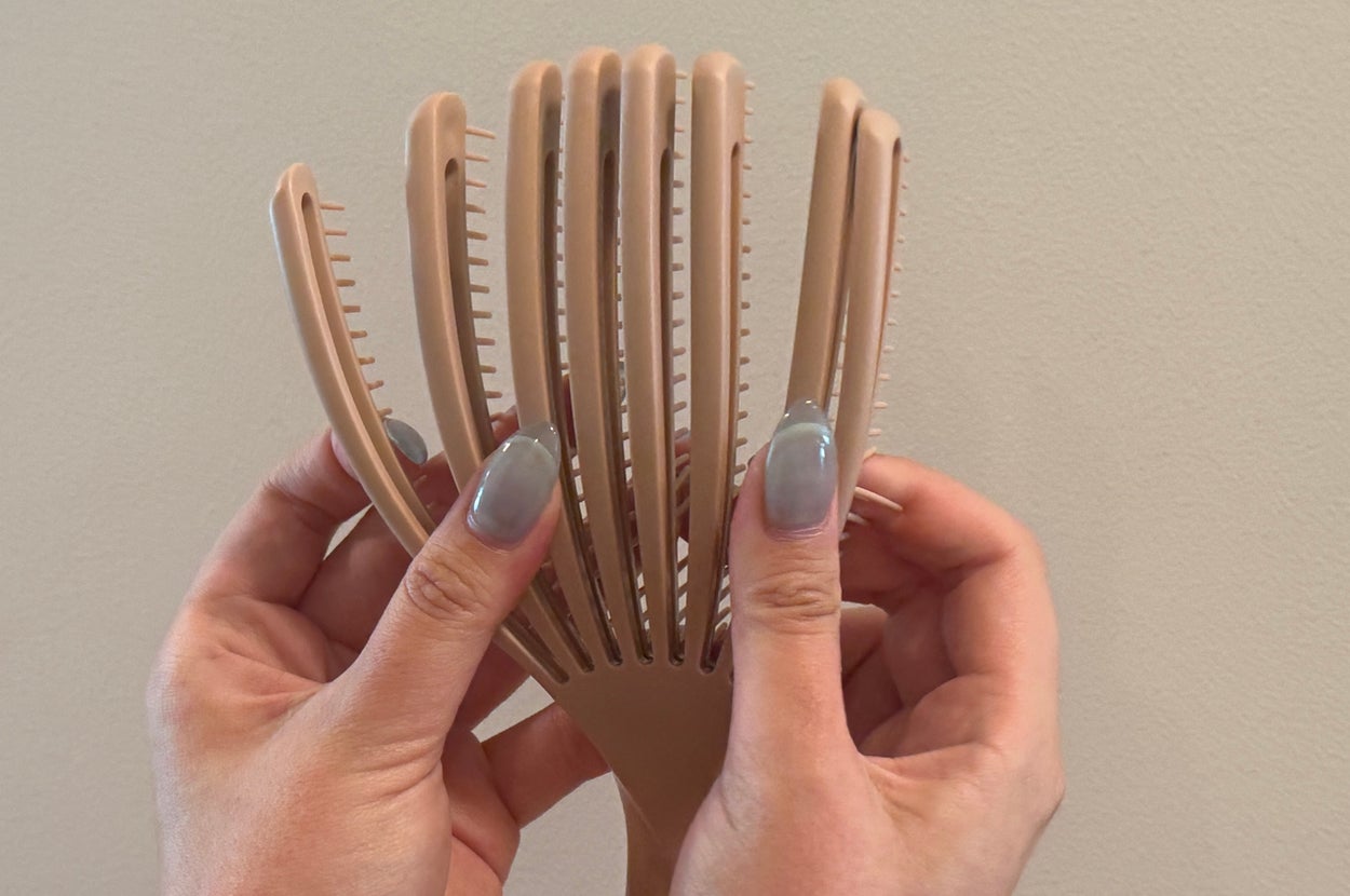 手に持たれている分岐した竹製のヘアブラシ。