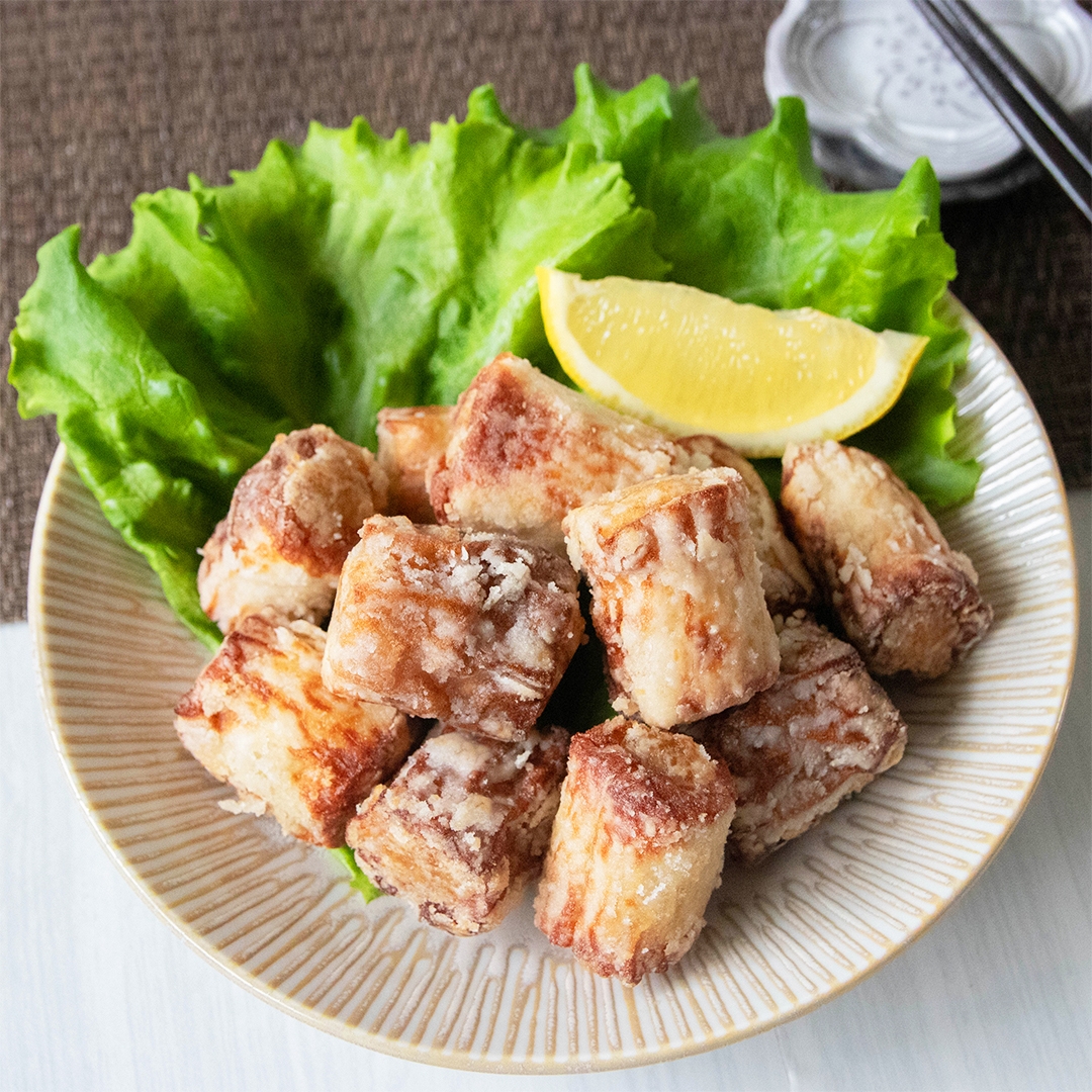 揚げ焼きにしたちくわの肉詰め唐揚げがレタスとレモンと共に皿に盛られた料理。