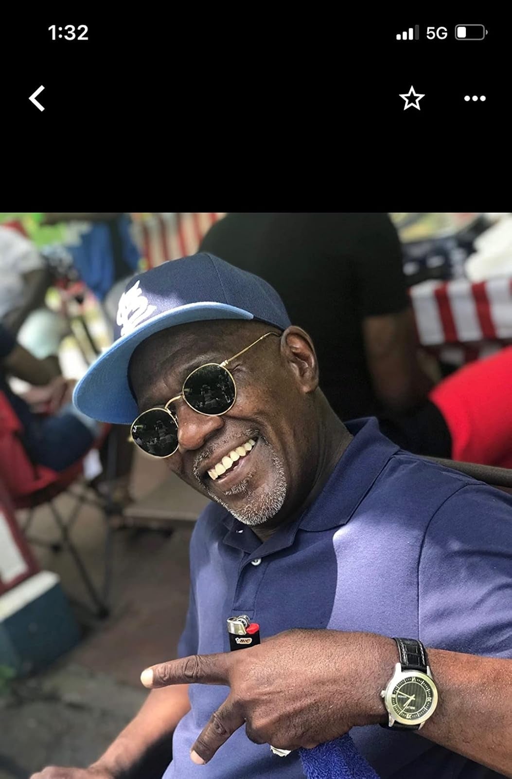 person successful  a casual polo garment  and headdress  smiles, wearing circular  sunglasses