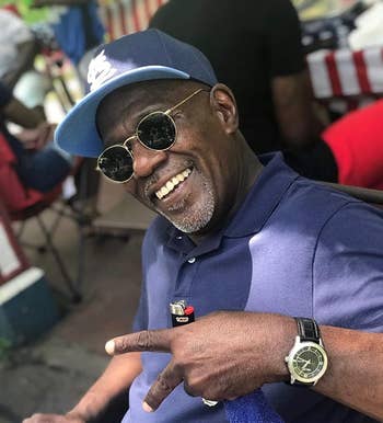person successful a casual polo garment and headdress smiles, wearing circular sunglasses