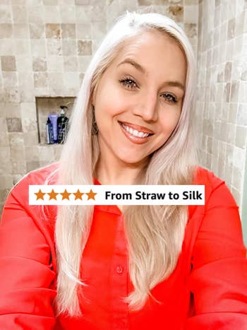 Person smiling successful a self-portrait wearing a button-up shirt, lasting successful a tiled bathroom. Hair and idiosyncratic attraction products are disposable successful the background