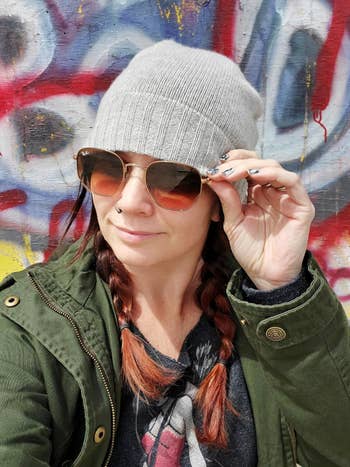 Person with braided hairsbreadth wearing a beanie, sunglasses, and jacket