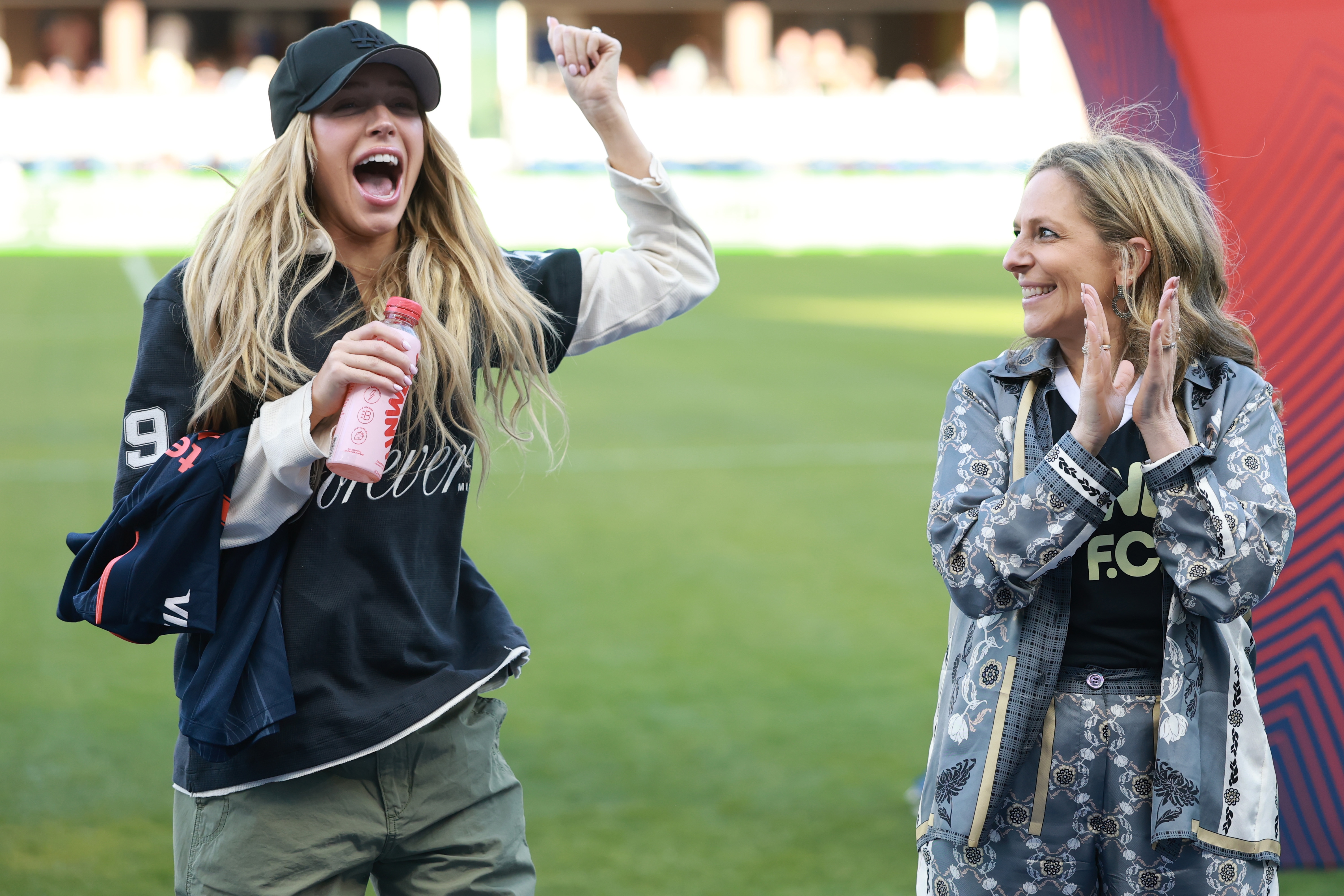 Alex Cooper and Jessica Berman cheer at a sports event