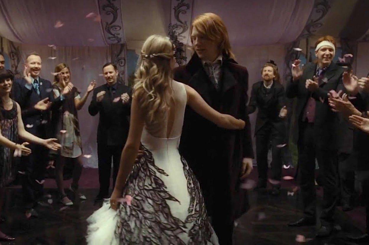 Harry Potter characters Bill and Fleur share a wedding dance surrounded by applauding guests
